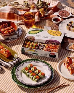 Plateaux de sushi variés et assortis avec des plats japonais servis sur une table à l'extérieur.