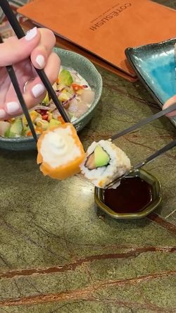 Deux personnes dégustent des sushis à emporter avec sauce soja dans un restaurant japonais à Lausanne.
