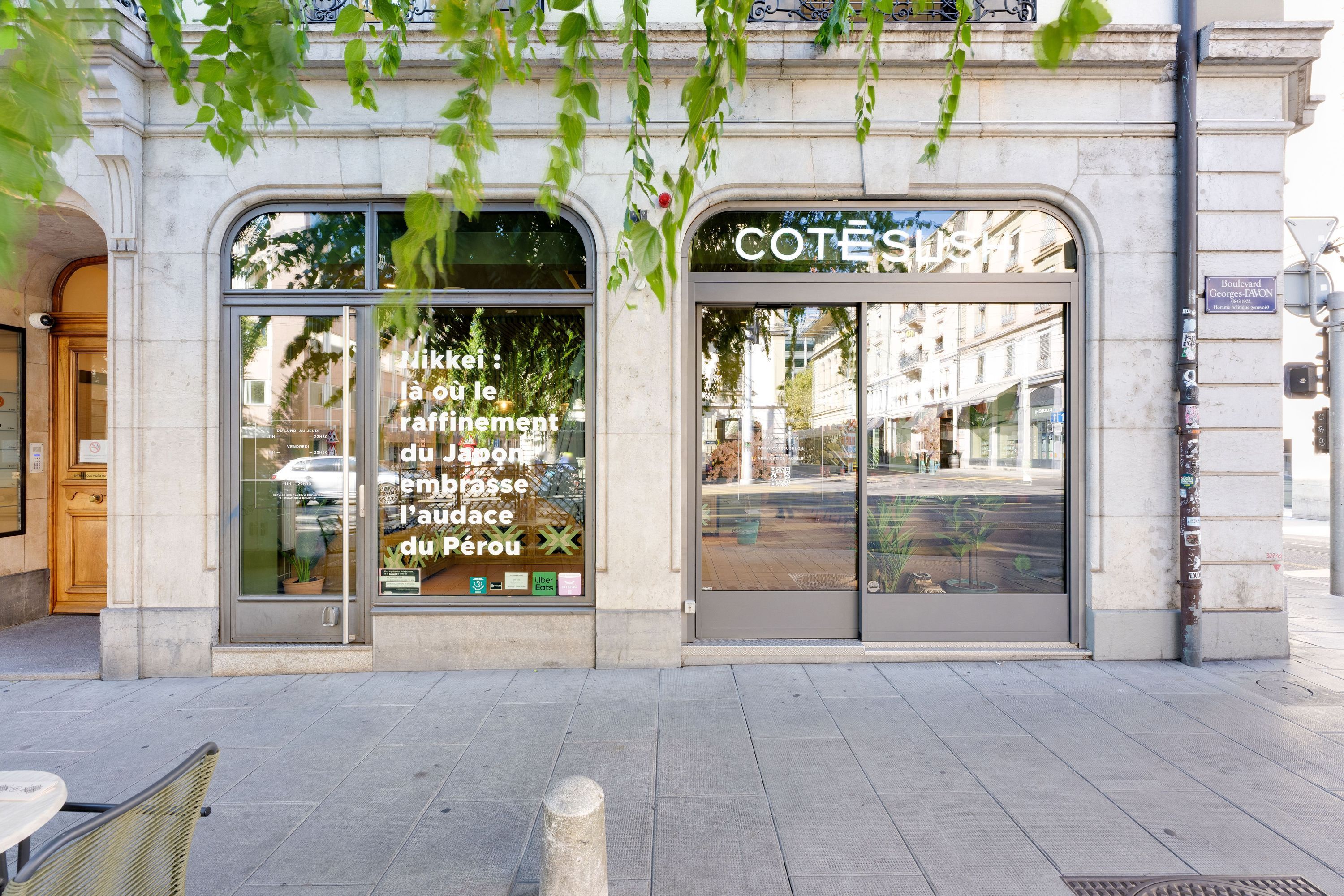 Façade du restaurant Côté Sushi Genève avec vitres vitrées et texte affiché sur la fenêtre sur un trottoir urbain